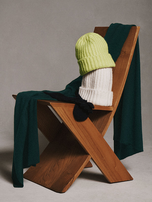 An image of White + Warren scarves and beanie hats in an array of colors on a chair