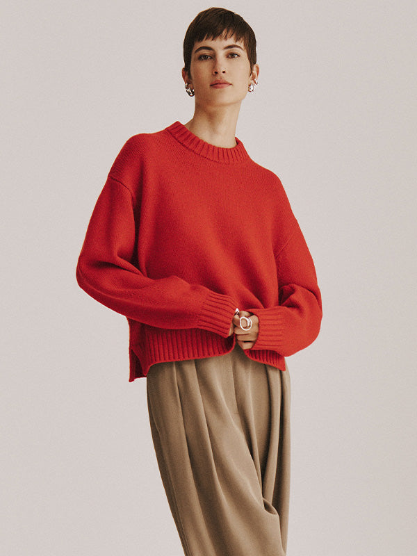 Model wears a White + Warren cashmere blend sweater with pants in studio.
